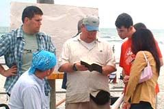 OAC evangelist sharing the Bible with passersby at the beach