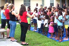 OAC trainees leading songs with kids in the open air